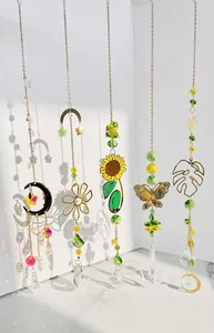 Golden suncatcher showing crystal prism refraction and rainbow light patterns on a white wall
