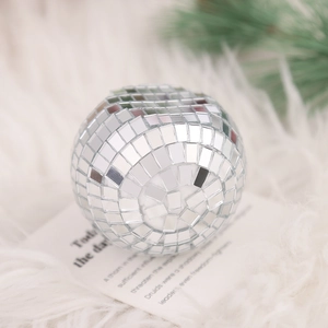 Close-up of a silver disco ball card holder with mirrored tiles on a festive background