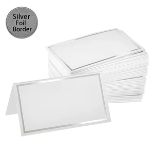 Detail of white place card with elegant silver foil border for wedding table settings