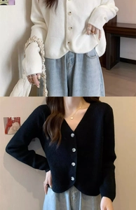 Detail of V-neck knit cardigans in beige and black featuring ruffled cuffs and buttons