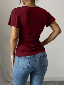 Slim fit burgundy short sleeve V-neck top for women shown from the back with blue jeans