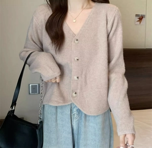 Close-up of V-neck knitted cardigan showing the ribbed texture and smooth buttons
