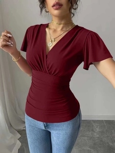 Detail of V-neckline and draped ruched waist on a dark red short sleeve slimming top