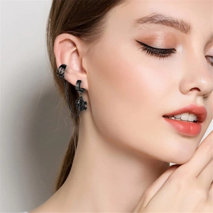 Detail eines schwarzen Gothic-Totenkopf-Ohrrings mit Kettenglied und Ohrmanschette
