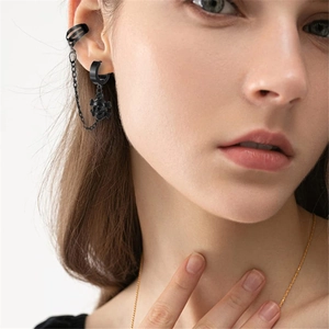 Schwarzer Gothic-Ohrring mit Totenkopf und Kette, präsentiert am Ohr eines Modells
