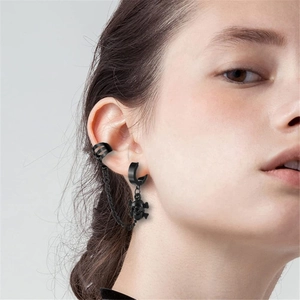 Makroaufnahme von schwarzem Gothic-Totenkopf-Ohrring mit Kette und Ohrmanschette