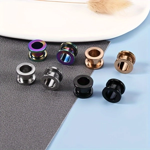 Detail van roestvrijstalen ear tunnels in zilver, zwart, roségoud en regenboogafwerkingen