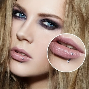 Vue macro d'un piercing arcade courbé en acier inoxydable avec pierres de zircon