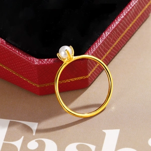 Makro-Detail des eleganten vergoldeten Rings mit runder weißer Perle in Krallenfassung