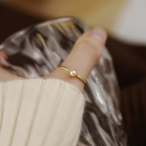 Eleganter Ring aus Gold-Titanstahl mit vierzackig gefasster Perle im Vintage-Stil