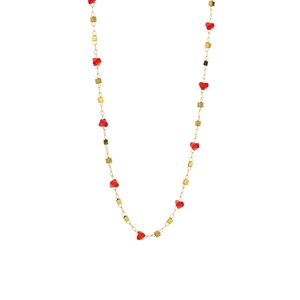 Gold necklace with red heart-shaped zircon stones and cubic gold beads on white background