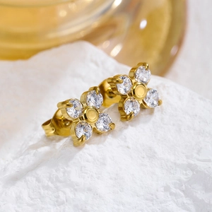 Dettaglio di orecchini a fiore con petali in zircone e placcatura in oro su pietra