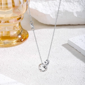 Silberne Doppelring-Halskette mit Kleeblatt-Mustern auf Stein und gelbem Hintergrund