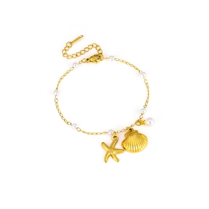 Detailansicht eines goldenen Perlenarmbands mit Seestern- und Muschelanhängern