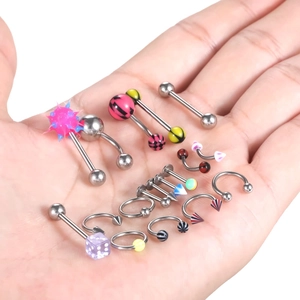 120-piece stainless steel piercing kit with various studs and rings displayed on hand