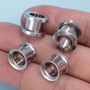 Macro-detail van gepolijste roestvrijstalen oortunnels en uitlopende oorpiercings