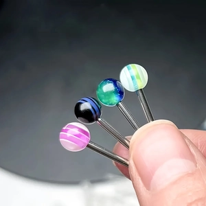 Macro detail of multi-colored 5mm acrylic piercing balls on stainless steel barbells