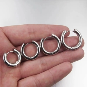 Polished silver stainless steel hoop earrings in four sizes displayed on a hand