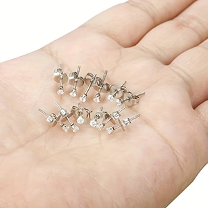 Set of minimalist stainless steel stud earrings with clear cubic zirconia in hand