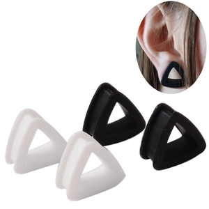 Triangle silicone ear gauges in black and white set with on-ear wearing example