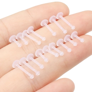 Hand holding set of 14 pink flexible acrylic labret studs for lip piercings