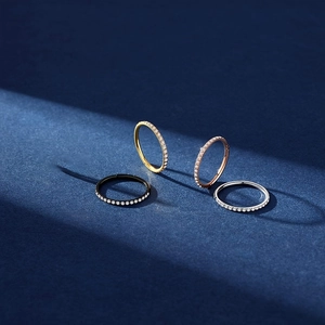 Detalle de cuatro anillos con bisagra en negro, oro, oro rosa y plata con circonitas