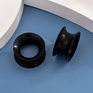 Makroaufnahme von schwarzen Silikon-Ohr-Plugs mit glatter, polierter Oberfläche