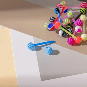 Détails des piercings de langue en acrylique coloré avec motifs à rayures et cœurs