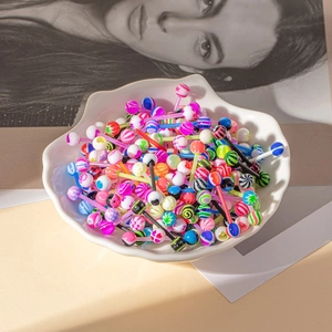 Gros plan de piercings de langue en acrylique colorés avec motifs variés dans un plateau