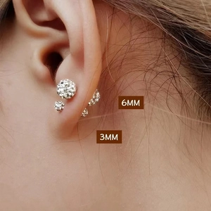 Detail of 3mm and 6mm sparkling crystal ball stud earrings on a model ear