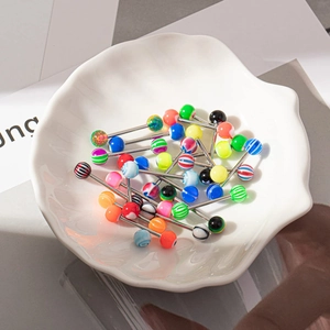 Gros plan de bijoux de langue en acrylique colorés dans un plat en coquillage