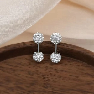 Macro shot of silver stainless steel double-sided crystal ball stud earrings on silk