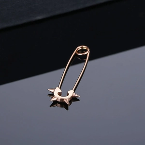 Gros plan de boucles d'oreilles épingle de nourrice or rose avec rivets style punk