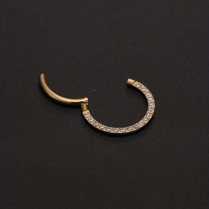 Macro shot of gold hinged segment nose ring with sparkling cubic zirconia inlay