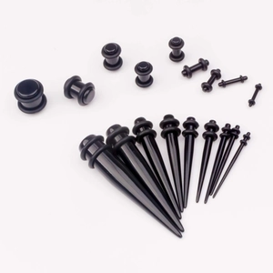 Collection of black acrylic ear tapers and plugs set in various sizes on white background
