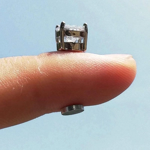 Macro view of magnetic stud earring showing silver claw setting and square zircon stone