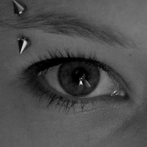 Close-up of a silver stainless steel spike eyebrow ring worn for a punk rock style