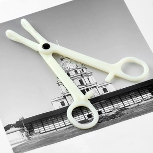 Detail of professional off-white plastic piercing forceps with serrated jaws and locking grip