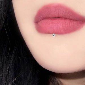 Nahaufnahme eines silbernen sternförmigen Zirkon-Lippenpiercings an der Unterlippe