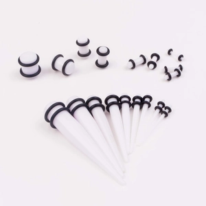 Macro shot of white acrylic ear taper and plug set with black rubber O-rings in various sizes