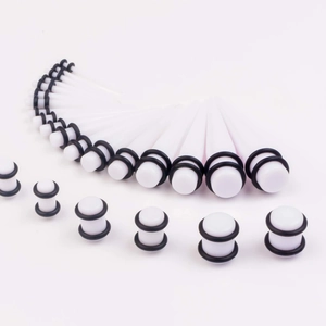 Detailed set of white acrylic ear stretching tapers and plugs with black O-rings