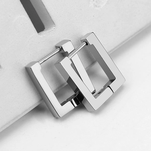 Macro shot of polished silver rectangular geometric hoop earrings with hinge closure