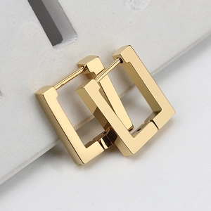 Macro shot of polished gold-finished rectangular geometric hinged hoop earrings