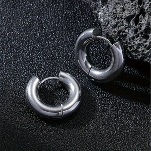 Vue macro de boucles d'oreilles créoles épaisses en acier inoxydable poli brillant