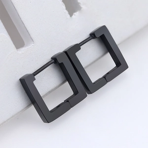 Macro shot of matte black stainless steel square hoop earrings on a geometric stand