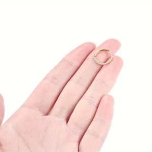 Nahaufnahme des goldenen Piercing-Rings mit Zirkonia-Steinen für Nase oder Ohrknorpel
