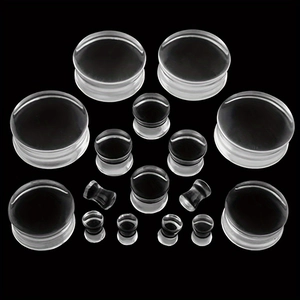 Set of clear double flare glass ear plugs in multiple gauges on black background