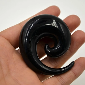 Detailopname van een gepolijste zwarte acryl spiraalvormige oordilatator voor stretching