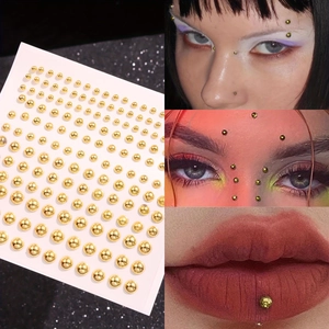 Golden faux body piercing stickers for face and lip decoration on white backing card