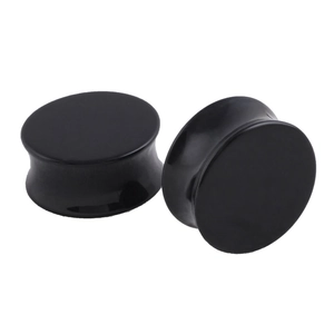 Macro view of double flared black acrylic ear plugs with high-polished reflective finish